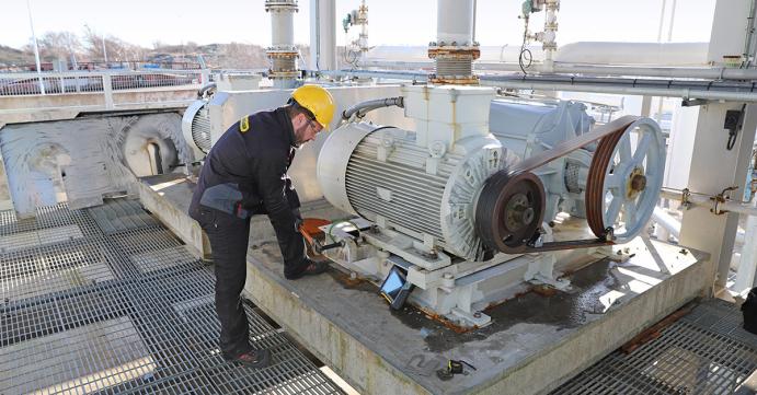 A man in a hard hat working on a machine.