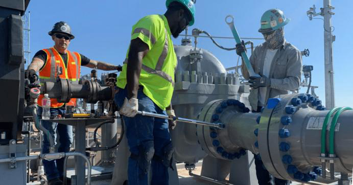 Men in hard hats installing a machine