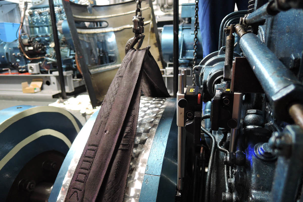 The flywheel held by a hook on a chain
