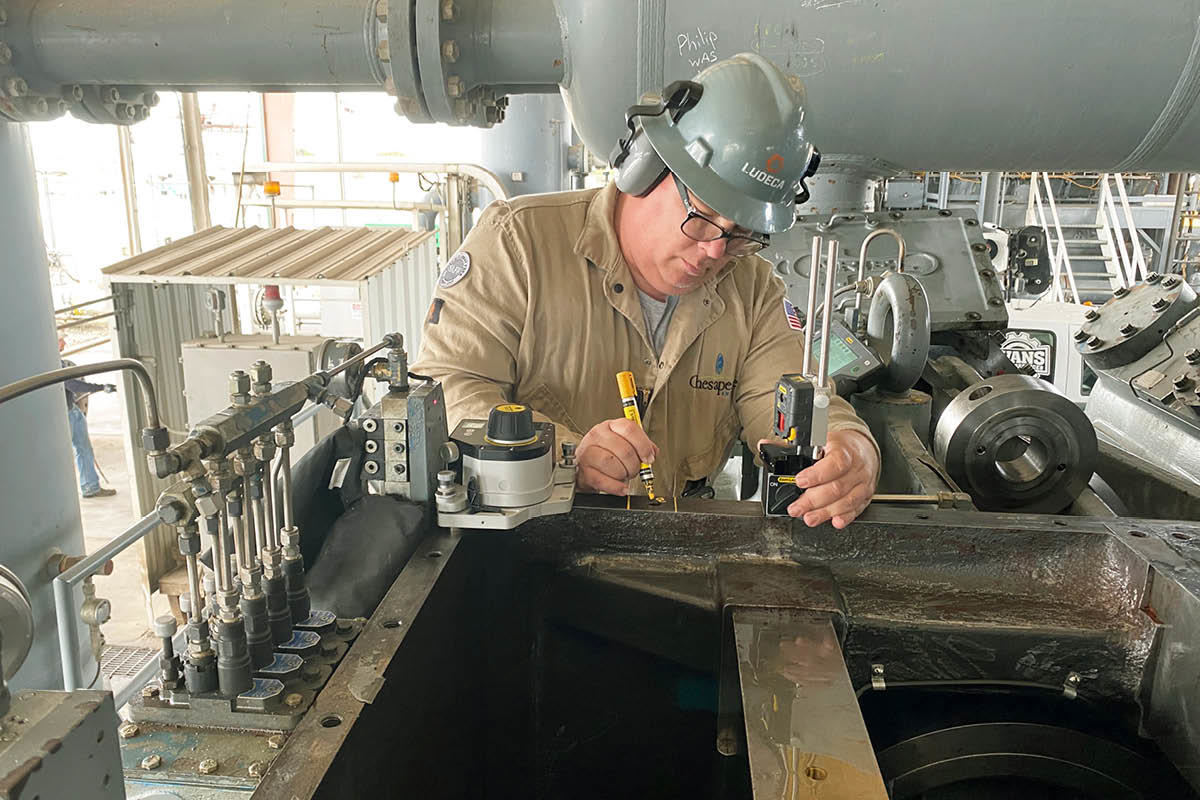 Man wearing helmet mounting equipment on cover rails